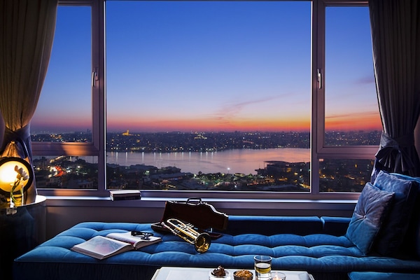 ميني بار وخزنة داخل الغرفة ومكتب وستائر تعتيم