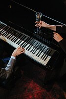A grand piano with a person playing it.