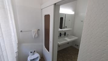 Un baño pequeño y privado con inodoro, bidé y lavamanos.