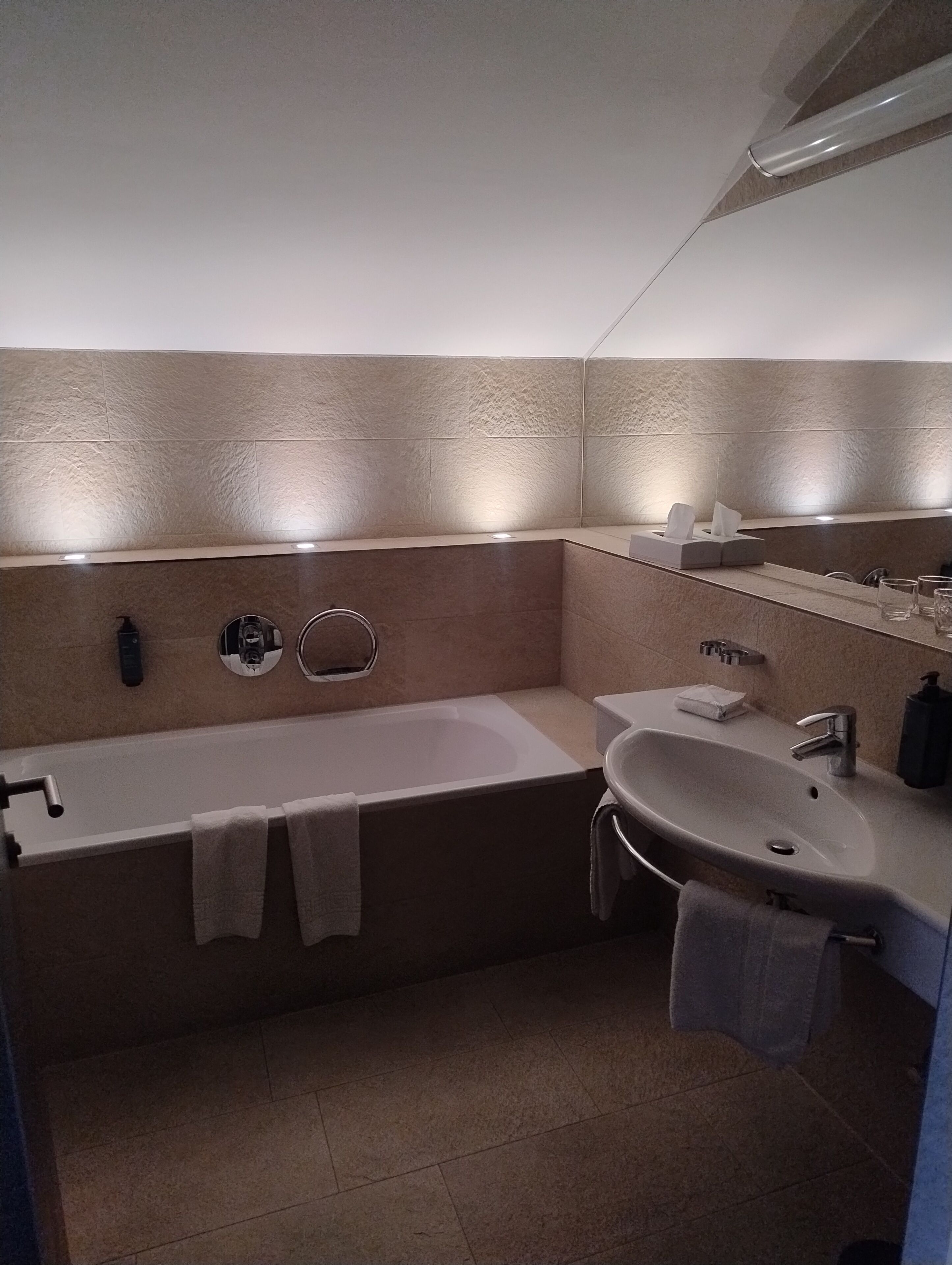 Un baño moderno con bañera, lavamanos y espejo.