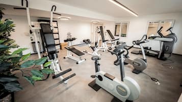 Un gimnasio con diferentes equipos de ejercicio, incluyendo cintas de correr y máquinas de pesas.