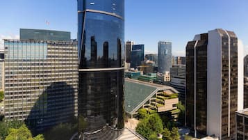 A modern cityscape with high-rise buildings, including a distinctive curved skyscraper and a rectangular building with a flat roof.
