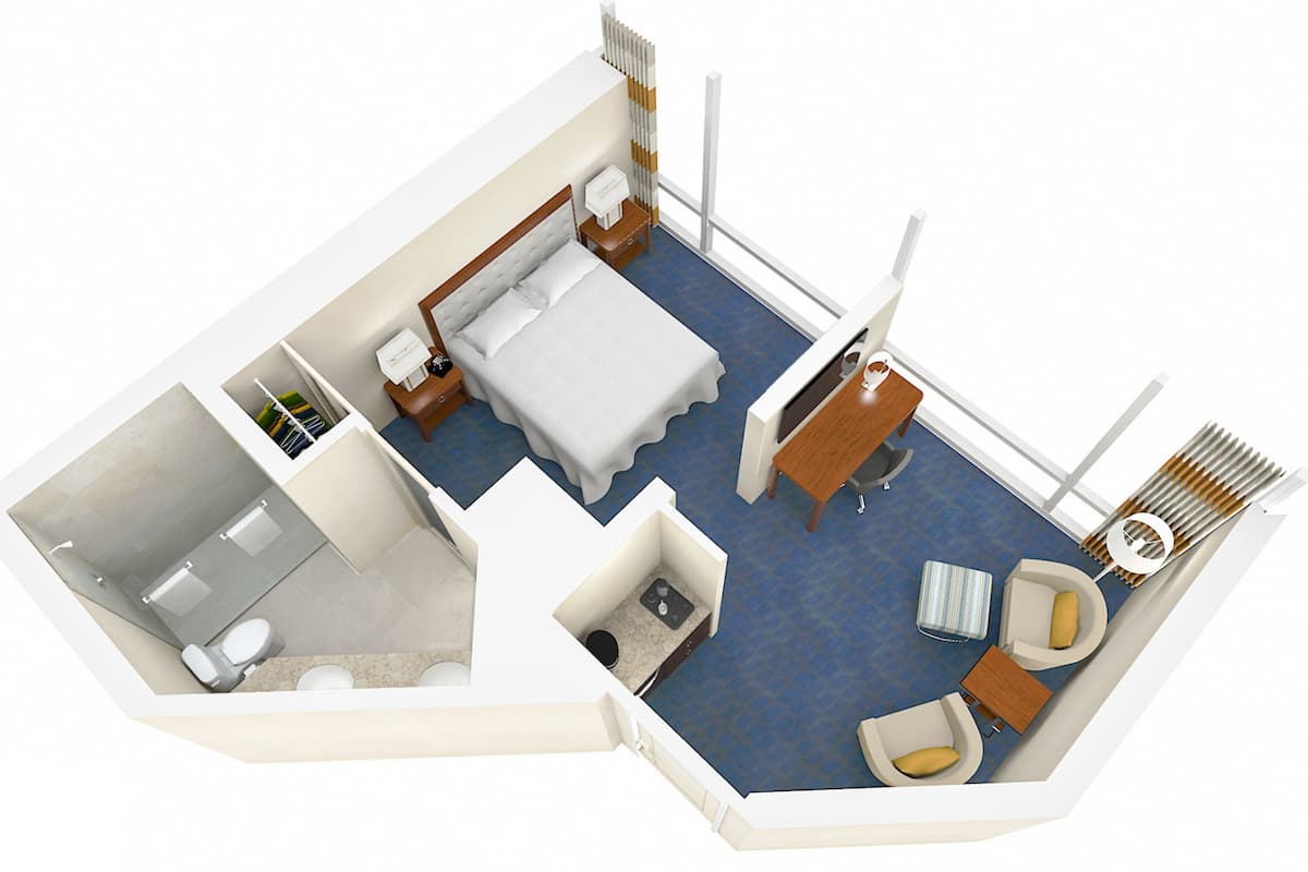 Habitación de hotel con cama, escritorio, silla, una mesita, sofá, ventana y baño.