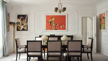 Un comedor con candelabro, obras de arte enmarcadas y una mesa dispuesta para seis comensales.