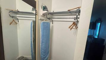 Un baño con espejo, toallero y cortina de ducha.