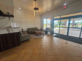 A reception area with a reception desk, seating, and large windows.