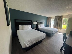 A hotel room with two beds, a desk, and a window with curtains. - Express Inn & Suites Greensville TX (Greenville)
