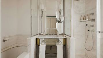 A modern bathroom with a bathtub, a sink with a mirror, and a shower area.