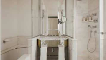Une salle de bain moderne avec une baignoire, un lavabo avec un miroir et un espace douche.