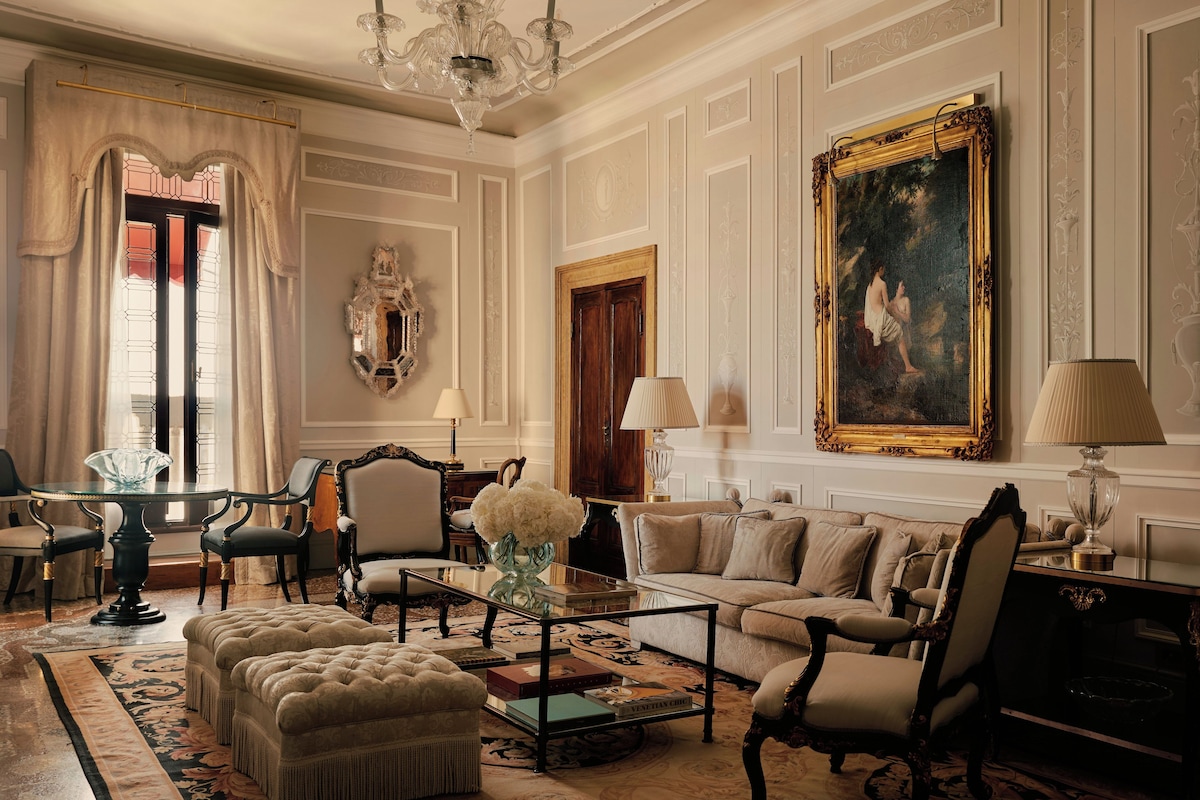 Una camera classica con un grande quadro, arredi eleganti e un lampadario.