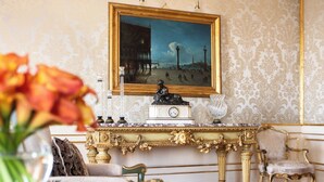 A room with a marble console table, a clock, a statue, and a chair. - Danieli, Venezia, A Four Seasons Hotel (Venice)