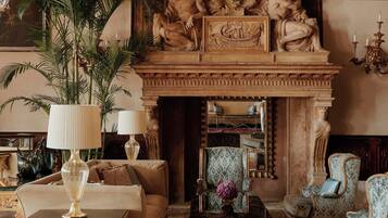 A luxurious room with a fireplace, ornate wall decorations, and classic furniture.