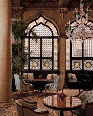 A luxurious interior with a grand arched window, elegant furniture, and a piano. - Danieli, Venezia, A Four Seasons Hotel (Venice)
