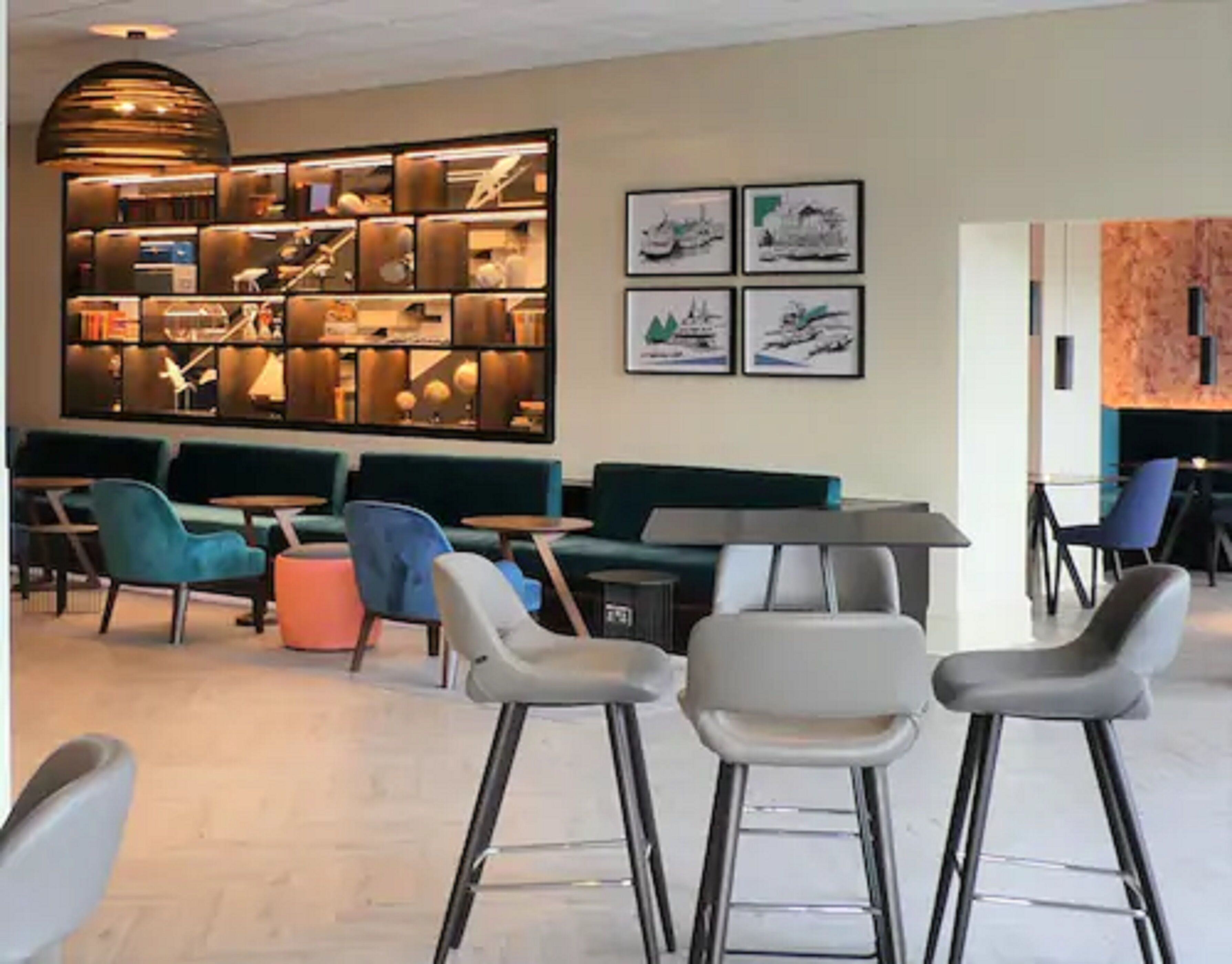 Ein modernes Interieur mit Barbereich, Sitzgelegenheiten und Kunstwerken an den Wänden.