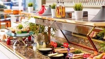 Een buffet met diverse gerechten en bijbehorende sauzen, waaronder een keuze uit kazen, fruit en vleeswaren.