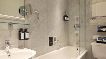Un baño moderno con bañera, lavamanos y cabina de ducha de vidrio.