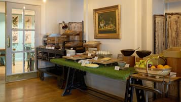 A buffet setup with various food items and a painting on the wall.