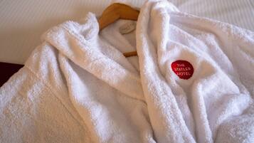 A white robe with a tag on a wooden hanger.