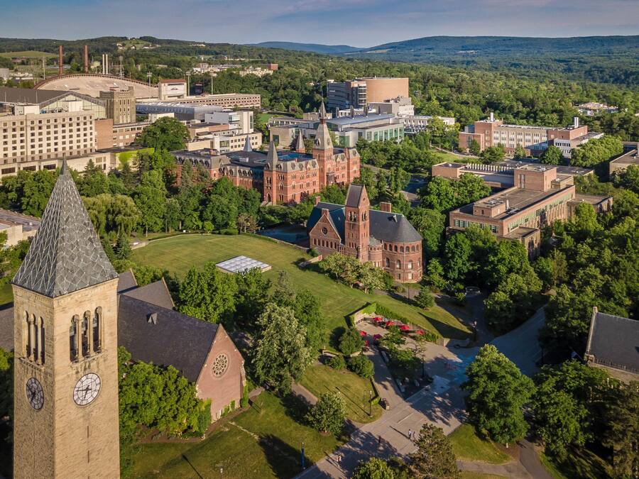 An aerial view of a campus with historic buildings, green spaces, and a prominent clock tower.