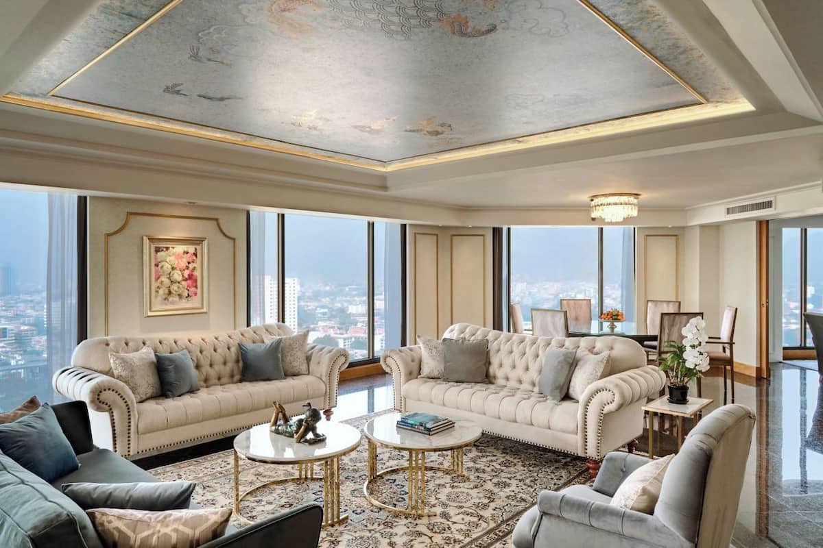Un salón lujoso con techo alto, ventanas grandes y vistas a la ciudad.