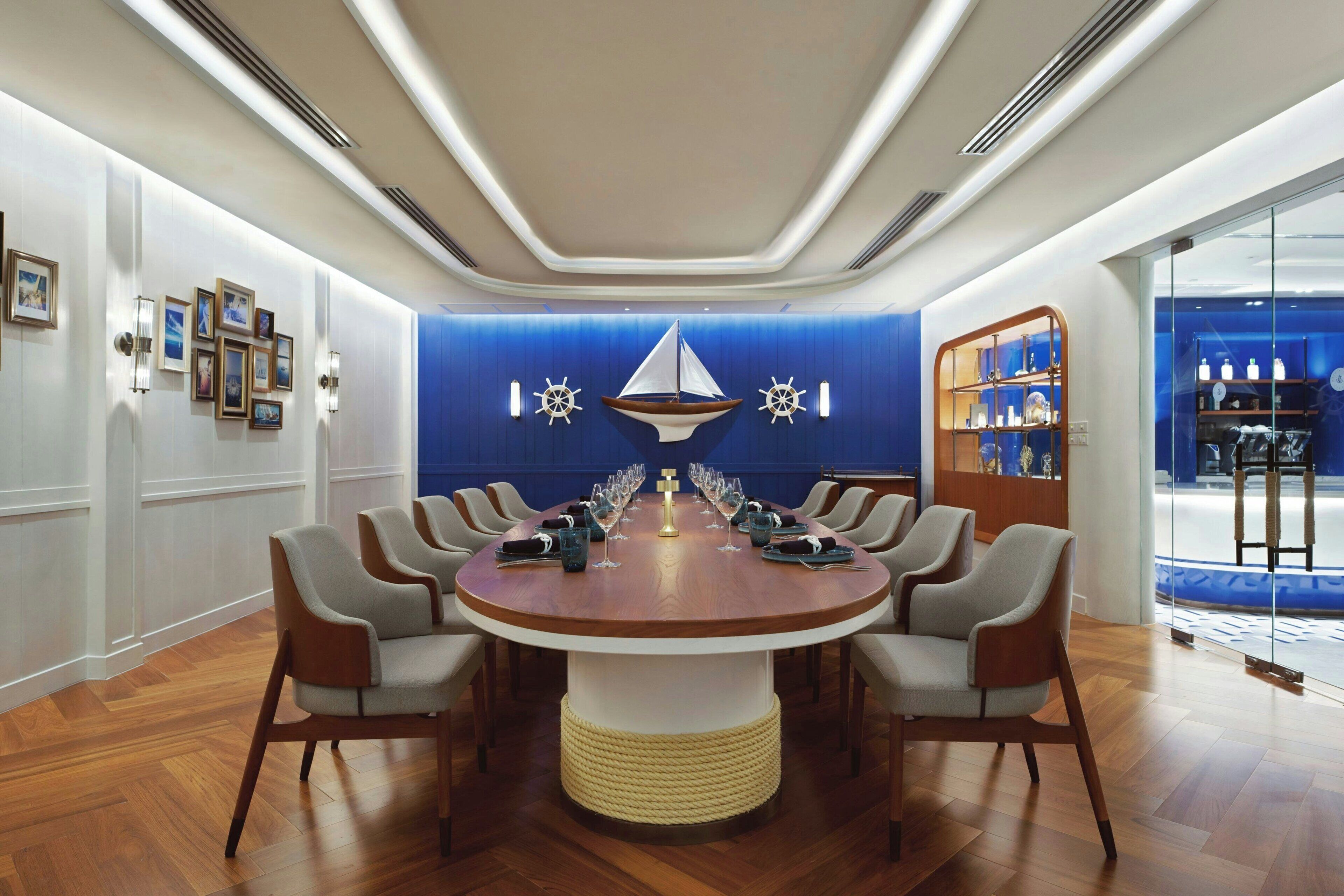 A round table with chairs, a blue accent wall, and a display of bottles.
