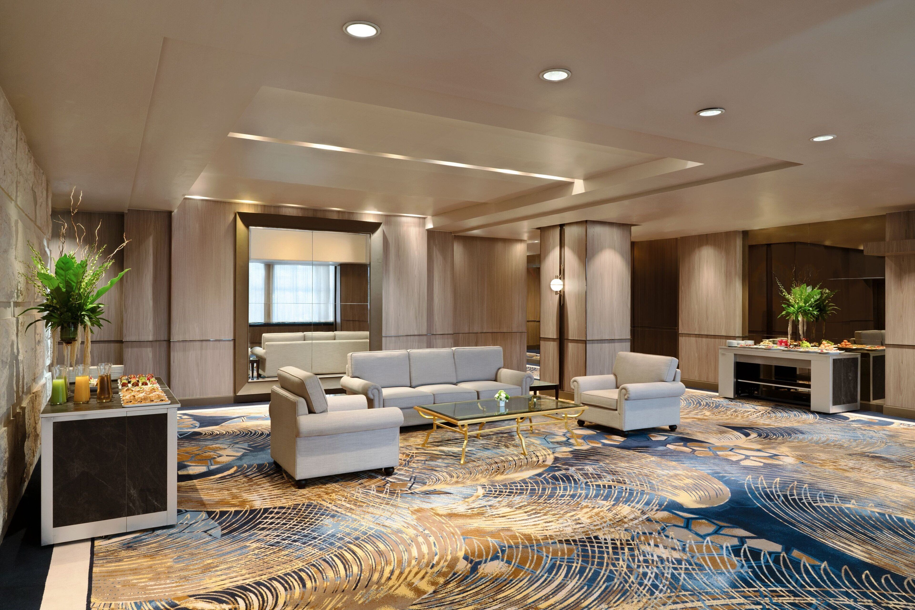 A modern living room with a large sofa, a coffee table, and a decorative rug.