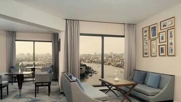 A modern hotel room with a city view, a dining area, and a seating area with a sofa and chairs.