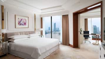Ruime hotelkamer met een groot bed, een bureau en uitzicht op een stadsgezicht.