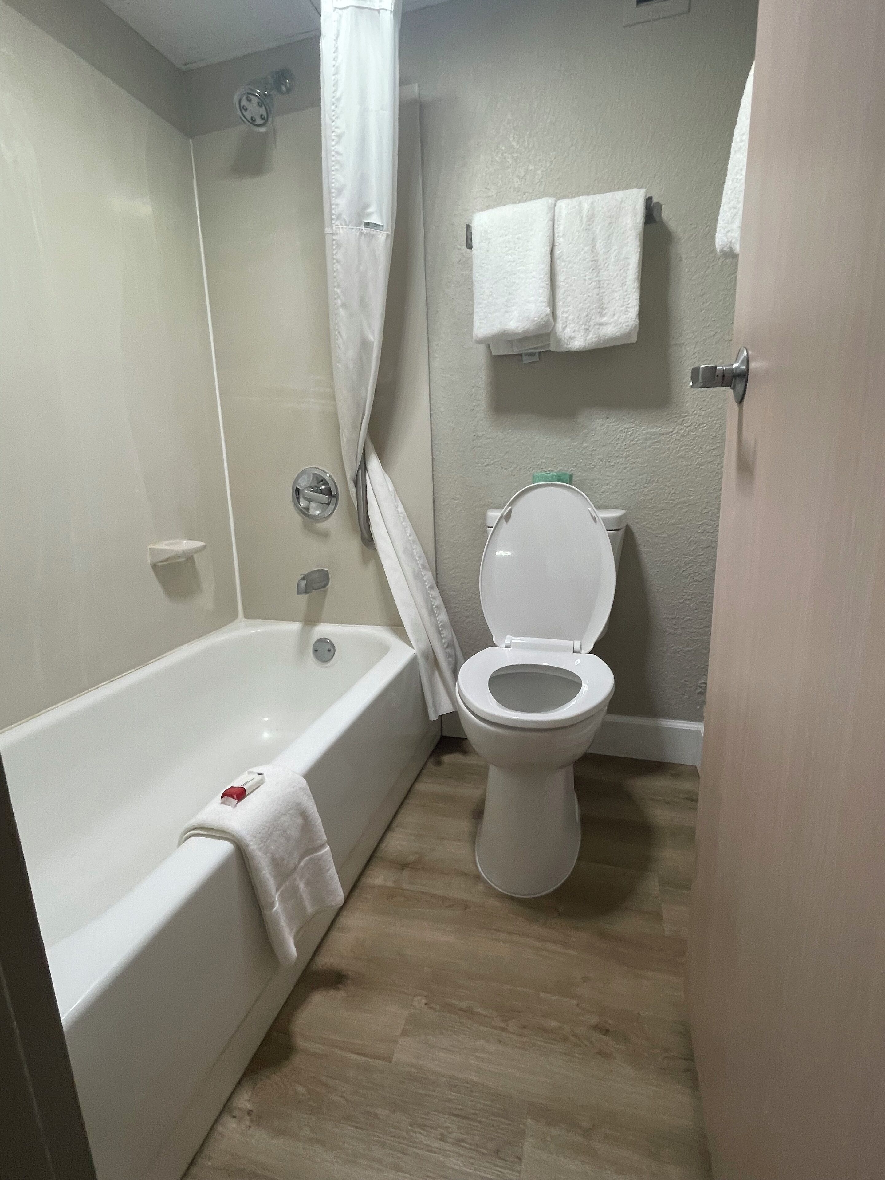 Ein Badezimmer mit Badewanne, Toilette und Duschvorhang.
