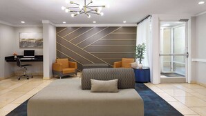 A modern hotel room with a large bed, two armchairs, a desk with a computer, and a decorative wall. - Days Inn by Wyndham Florence Near Civic Center (Florence)