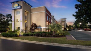A Days Inn hotel with a modern design, featuring a parking lot and well-maintained landscaping. - Days Inn by Wyndham Florence Near Civic Center (Florence)