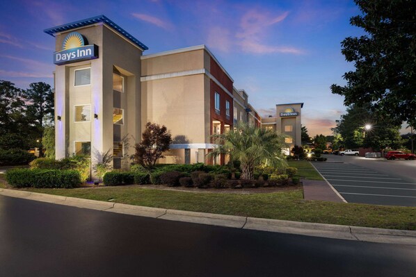 A Days Inn hotel with a modern design, featuring a parking lot and well-maintained landscaping.