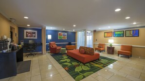 A lobby with a reception desk, seating area, and artwork on the walls. - Days Inn by Wyndham Florence Near Civic Center (Florence)