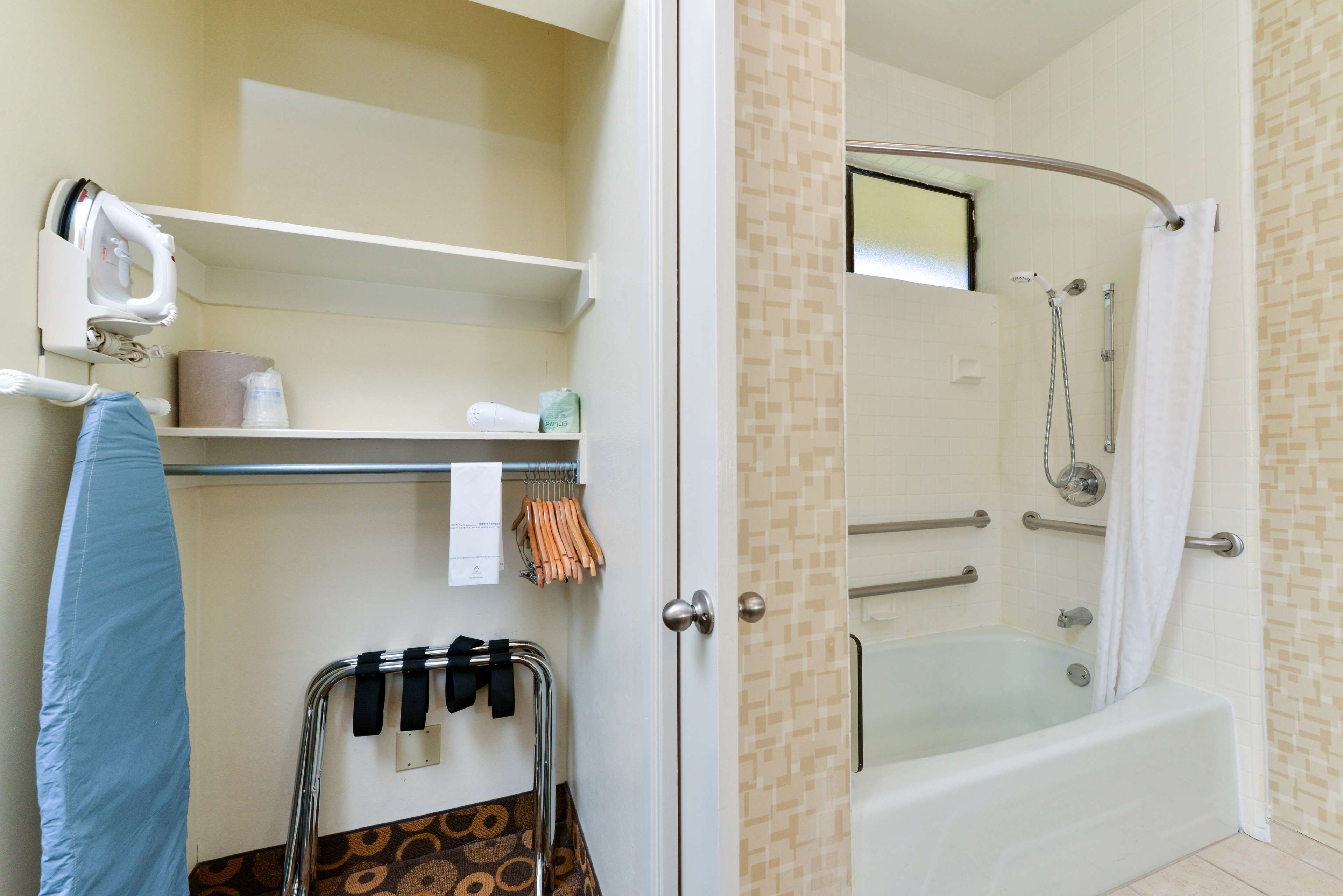 A bathroom with a shower, a towel rack, and a hairdryer.