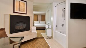 A hotel room with a fireplace, a bed, a shower, and a TV. - Best Western Corte Madera Inn (Corte Madera)