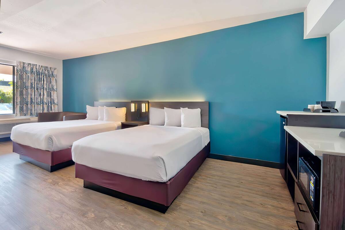 Ein Hotelzimmer mit zwei Betten, einem Schreibtisch und einer Minibar.