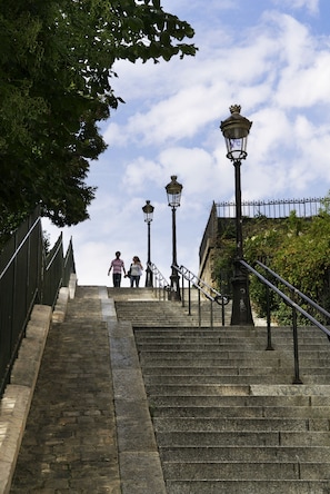 A set of stone steps with metal railings and street lamps, leading up to a building. - Mercure Paris Montmartre Sacré Coeur (Paris)