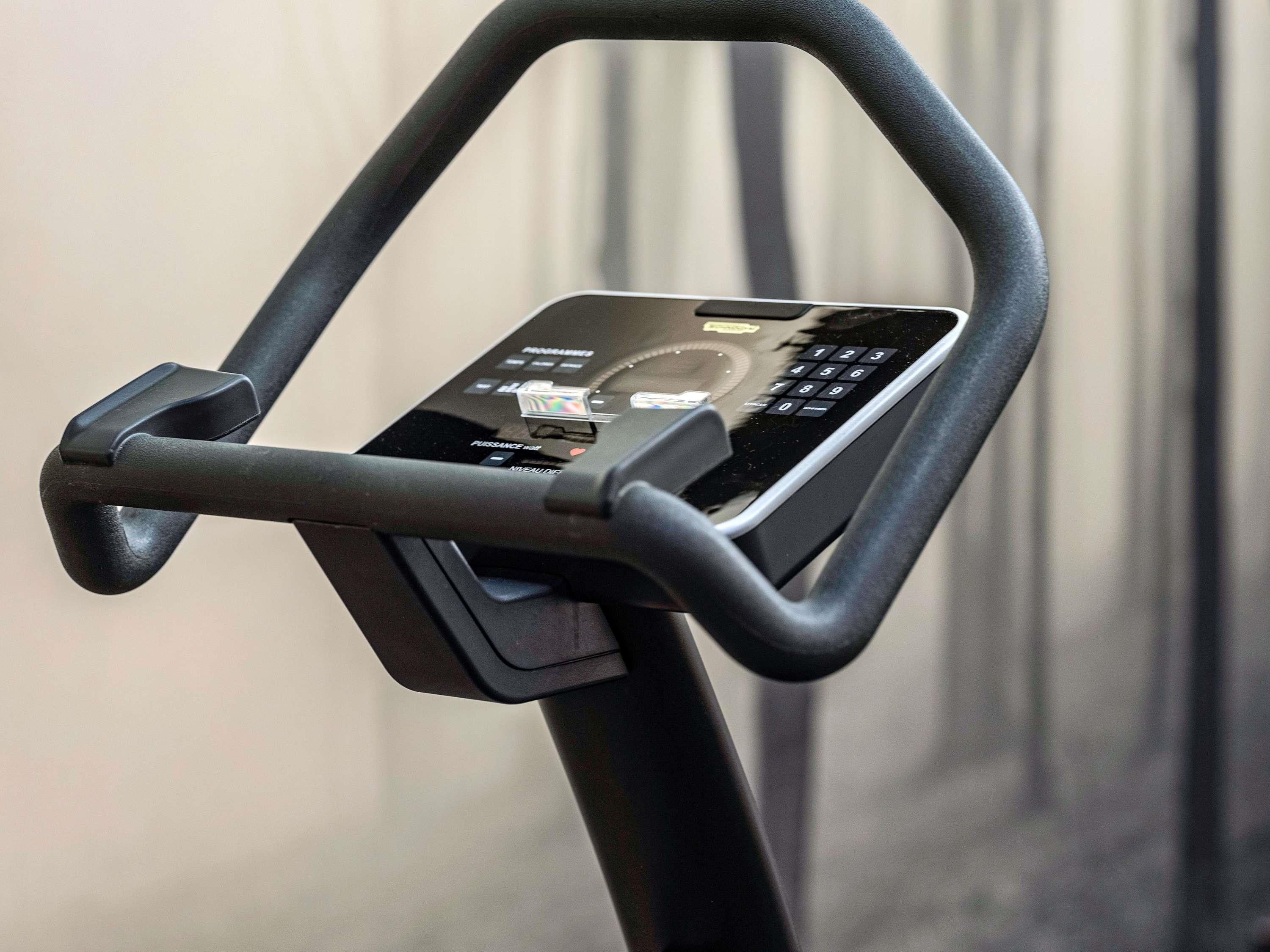 A stationary exercise bike with a digital display and control panel.