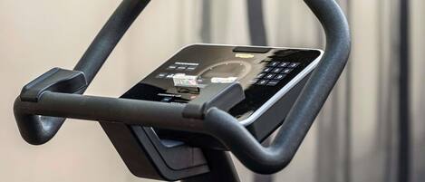 A stationary exercise bike with a digital display and control panel.