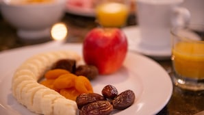 Une assiette de petit-déjeuner avec une banane, une pomme et des noix.