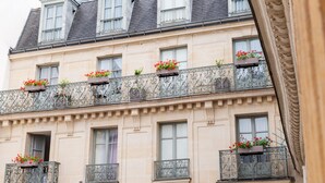 Un immeuble à plusieurs étages doté de balcons ornés de jardinières.