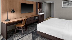 A hotel room with a bed, desk, chair, TV, microwave, and a framed picture on the wall. - DoubleTree by Hilton Dayton Fairborn (Fairborn)