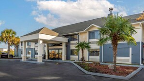 A modern hotel with a covered entrance, palm trees, and a parking lot. - Comfort Inn & Suites - near Robins Air Force Base Main Gate (Warner Robins)
