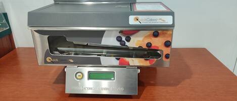 A Quick Cakes breakfast machine with a digital display and a push button.