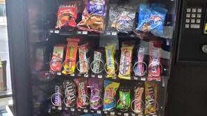 A vending machine stocked with various snacks. - Cedar Cove (Sandusky)