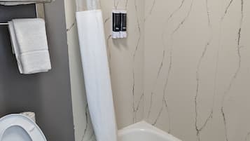A bathroom with a bathtub, toilet, and towel rack.