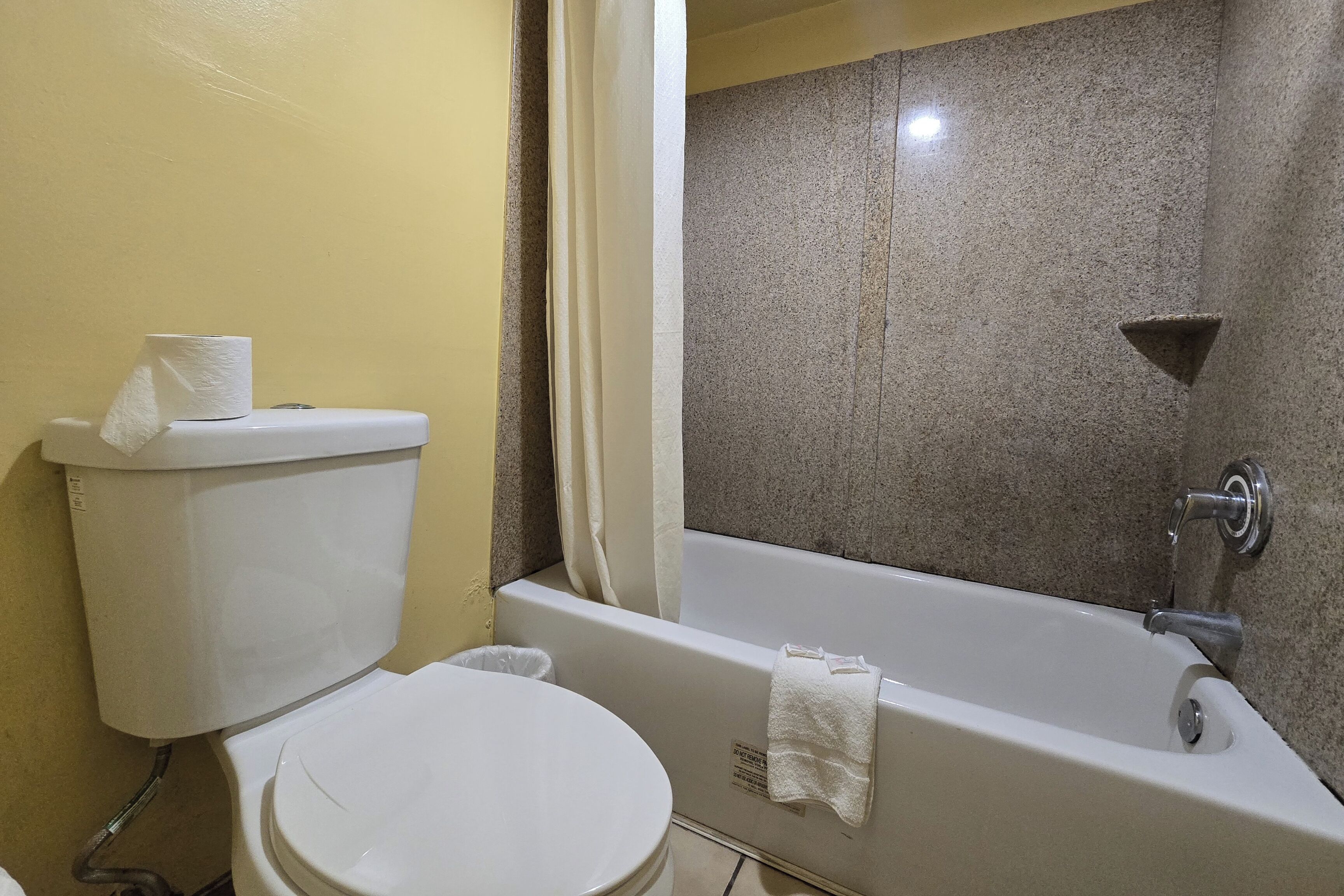 Un bagno con il water, una vasca e una tenda per la doccia.