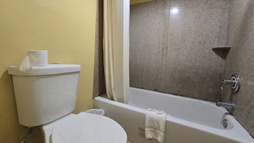 Une salle de bain équipée de toilettes, d’une baignoire et d’un rideau de douche.