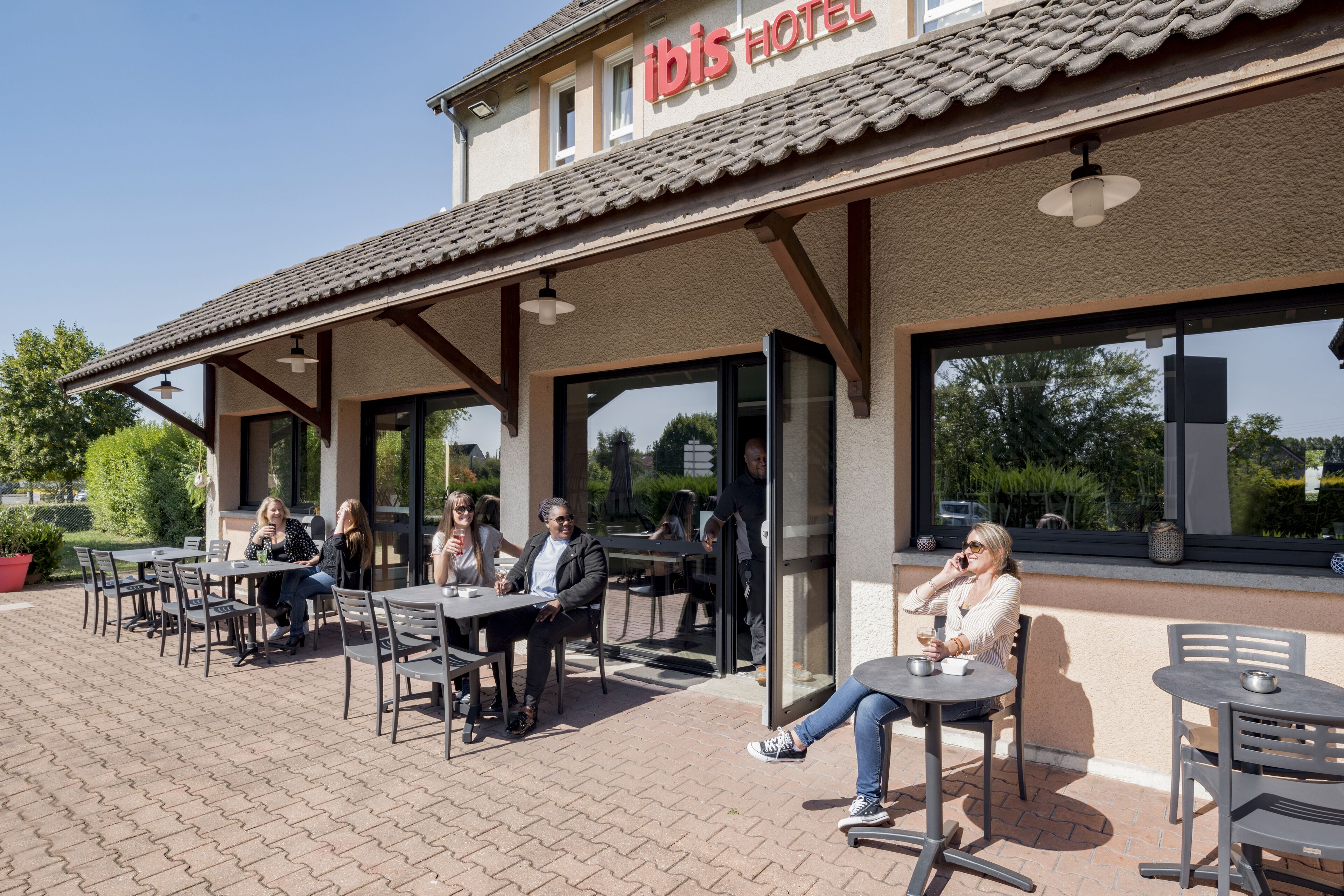 An outdoor seating area with tables and chairs at a hotel.