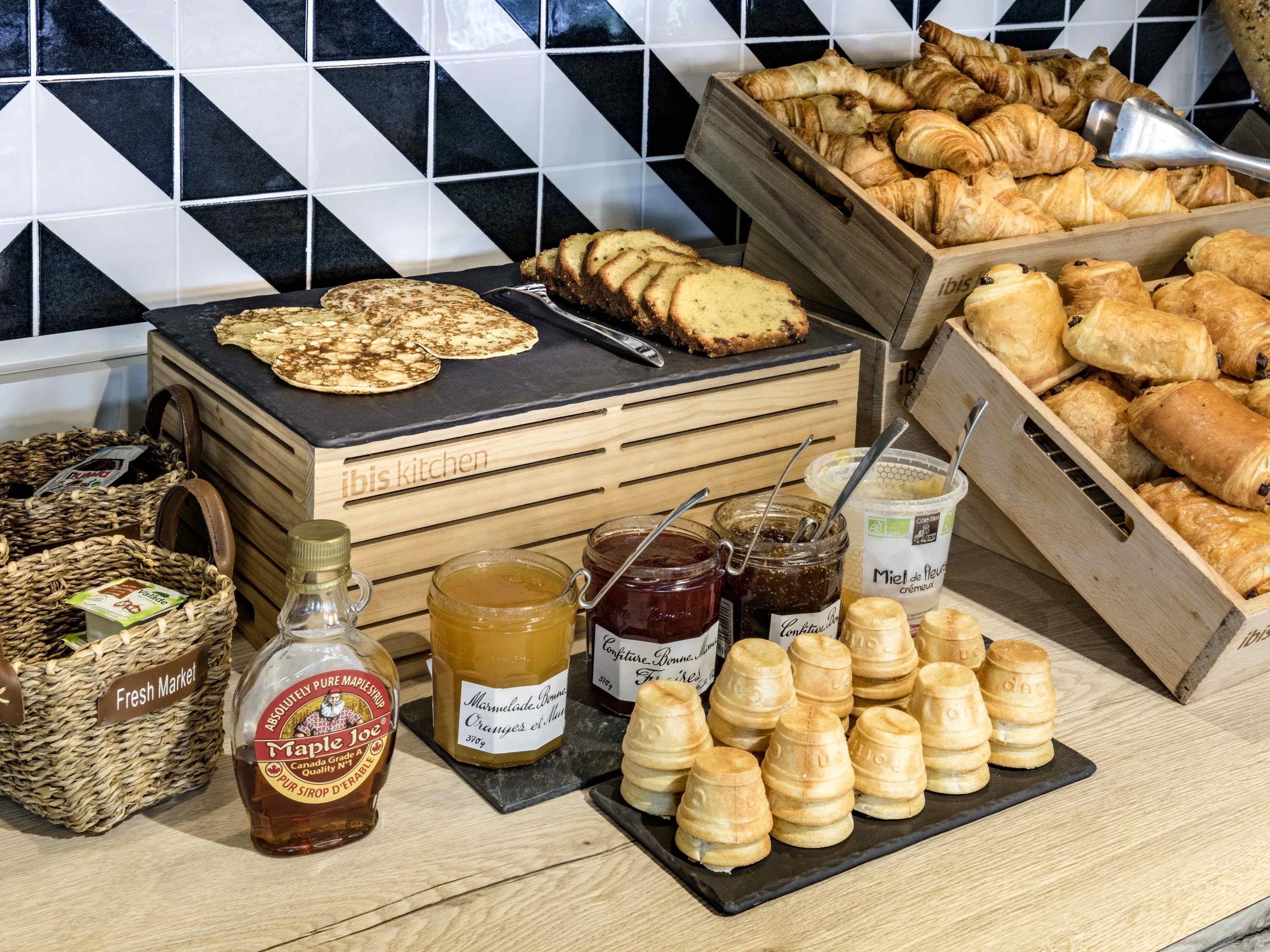 Ein Frühstücksbuffet mit Gebäck, Brot und Marmeladen.